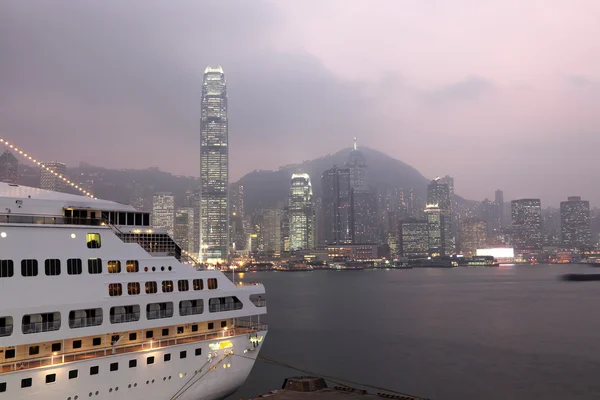 Kreuzfahrtschiff und Skyline von Hongkong in der Abenddämmerung — Stockfoto