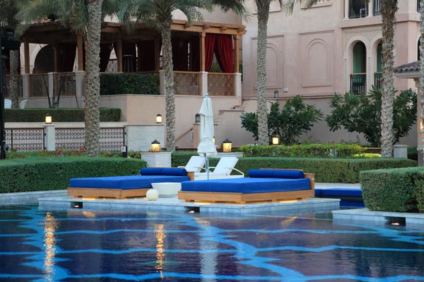 Piscina com espreguiçadeiras em um hotel resort de luxo. Dubai, Emirados Árabes Unidos — Fotografia de Stock