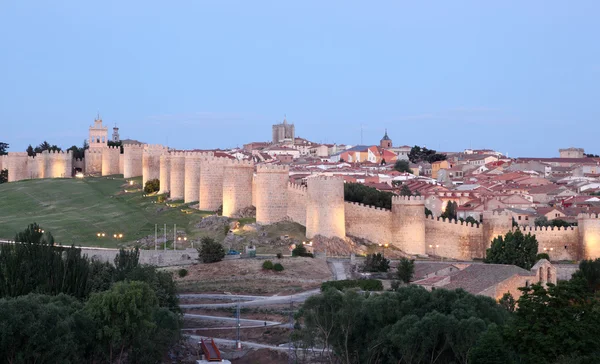 Medieval city walls of Avila illuminated at dusk. Castile and Leon, Spain Stock Picture