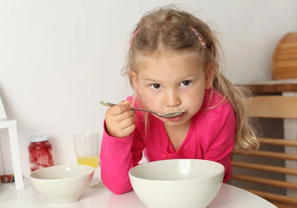 Bonito menina de quatro anos come sopa em casa — Fotografia de Stock