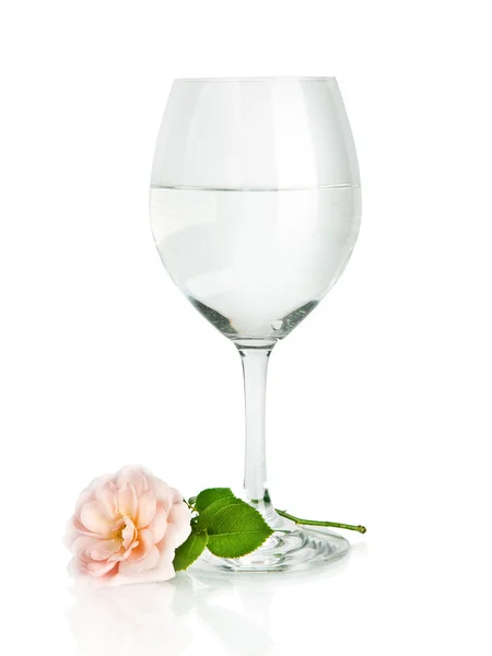 Kieliszek do wina z wodą i różowy kwiat róży na białym tle — Zdjęcie stockowe