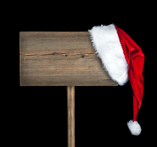 Wooden road sign with Santa hat isolated on black background — Stock Photo, Image