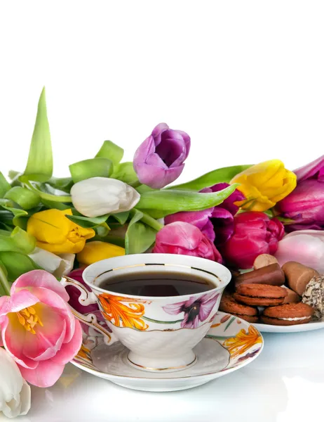 Bouquet of colorful tulips and tea cup full of tea isolated on — Stock Photo, Image