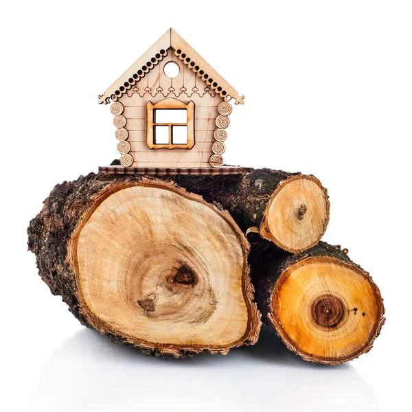 Drewniany model domu i stos drewna. koncepcja — Zdjęcie stockowe