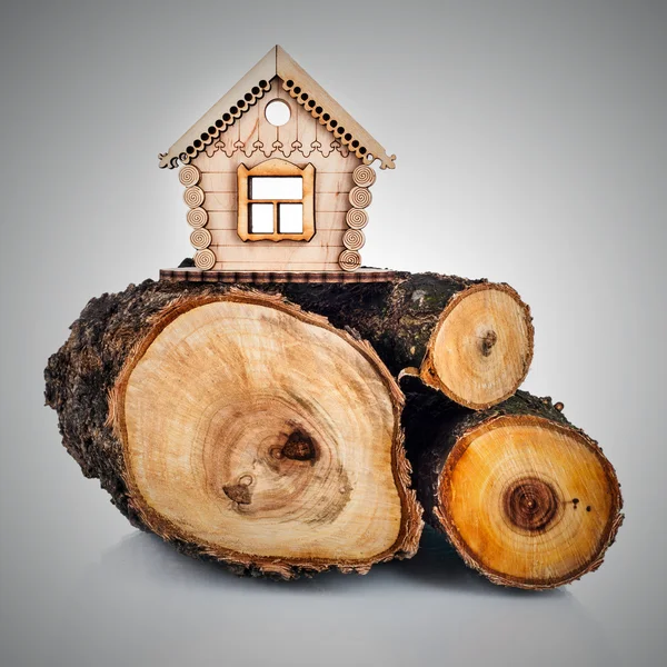Drewniany model domu i stos drewna. koncepcja — Zdjęcie stockowe
