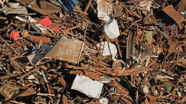 Metal hurda arka planı. Geri dönüşüm için depolanmış hurda metal yığını. Depoda metal atıkları geri dönüşüm. Vinç limanda hurda metali boşaltıyor. Geri dönüşüm metal atıkları boşaltılıyor