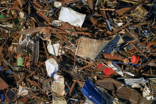 Metal scrap background. Heap of scrap metal stored for recycling. Recycling metal waste in warehouse. Grab crane unloads scrap metal in port. Unloading recycle metal waste