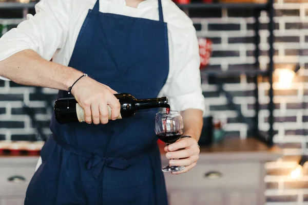 Man Blue Apron White Shirt Standing Kitchen Opens Bottle Red Стоковое Фото