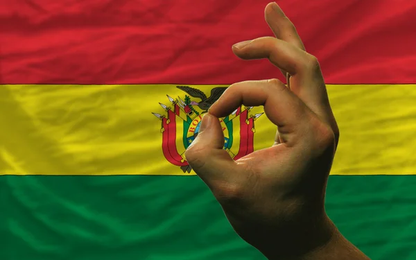 OK gesto před státní vlajky Bolívie — Stock fotografie