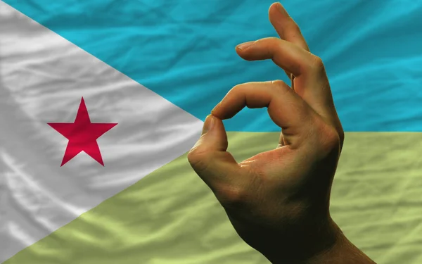 Ok gesture in front of Djibouti national flag — стоковое фото