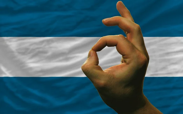 Ok gesto frente a la bandera nacional del salvador — Foto de Stock