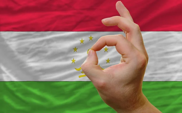 Gesto ok na frente da bandeira nacional do tajiquistão — Fotografia de Stock
