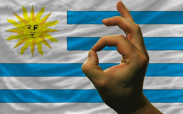 Ok gesto frente a la bandera nacional uruguay —  Fotos de Stock