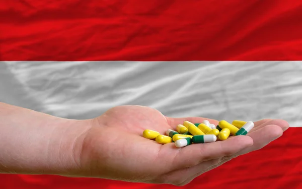 Держа в руках таблетки перед национальным флагом Австралии — стоковое фото