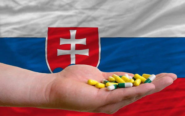 Anläggningen piller i handen framför Slovakien nationella flagga — Stockfoto