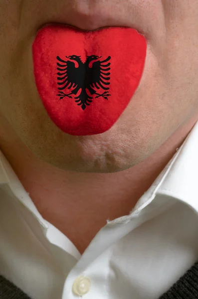 Język człowieka malowane w Albanii flagę symbolizującą wiedzy do s — Zdjęcie stockowe