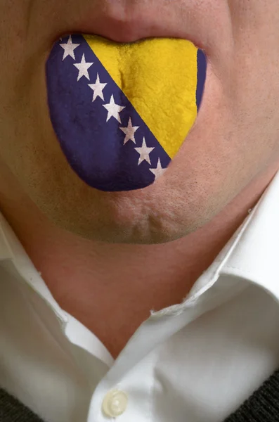 Man tongue painted in bosnia herzegovina flag symbolizing to kno — Stock Photo, Image