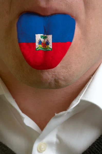 Männerzunge in Haitiflagge gemalt als Symbol für Wissen to spe — Stockfoto