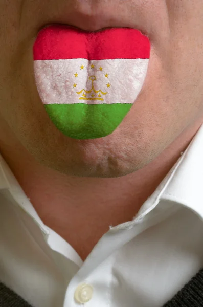Man tongue painted in tajikistan flag symbolizing to knowledge t — Stock Photo, Image