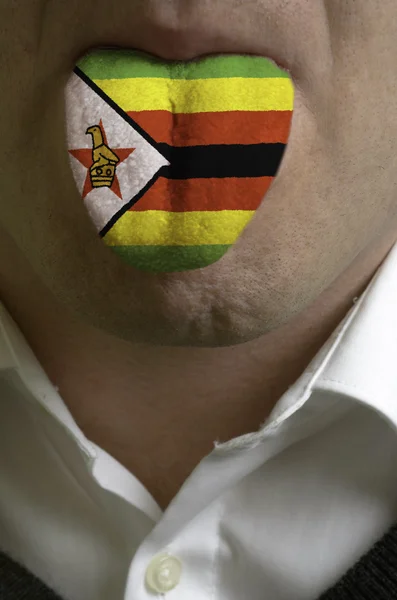 Männerzunge in Zimbabwe-Flagge gemalt, die das Wissen symbolisiert — Stockfoto