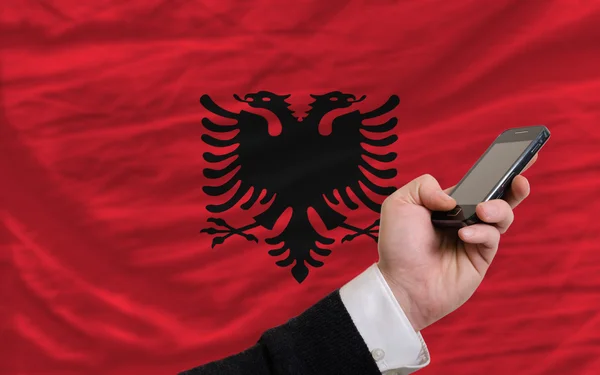 Telefone celular na frente bandeira nacional de albania — Fotografia de Stock