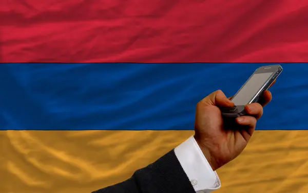 Мобильный телефон перед национальным флагом Армении — стоковое фото