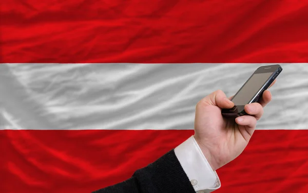 Cell phone in front national flag of austria — Stok fotoğraf