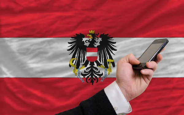 Cell phone in front national flag of austria — Stockfoto