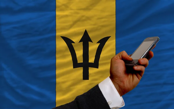 Handy vor Nationalflagge von Barbados — Stockfoto