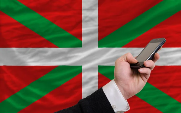 Mobilní telefon v přední národní vlajka baskické — Stock fotografie