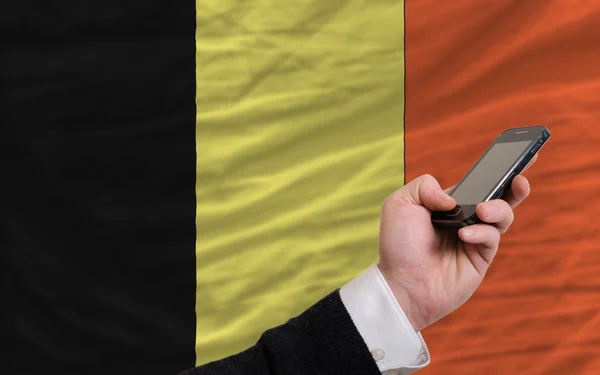 Telefone celular na frente bandeira nacional da Bélgica — Fotografia de Stock