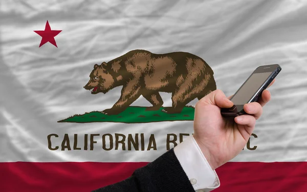 Teléfono celular en frente de la bandera del estado americano de California —  Fotos de Stock