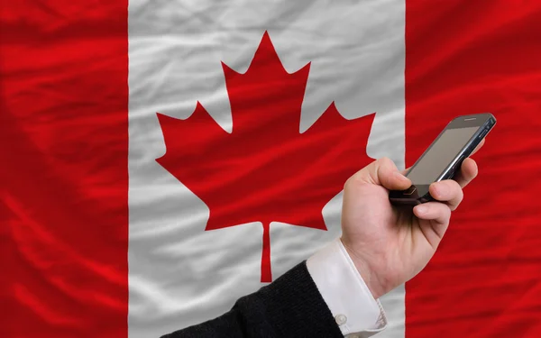 Mobilní telefon v přední národní vlajka Kanady — Stock fotografie