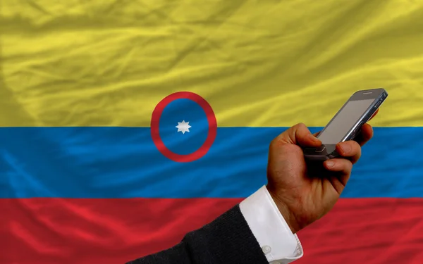 Мобильный телефон перед национальным флагом Колумбии — стоковое фото