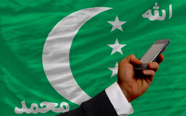 Mobiele telefoon in front nationale vlag van Comoren — Stockfoto