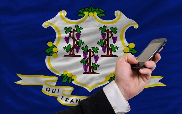 Teléfono celular en frente de la bandera del estado americano de Connecticut — Foto de Stock