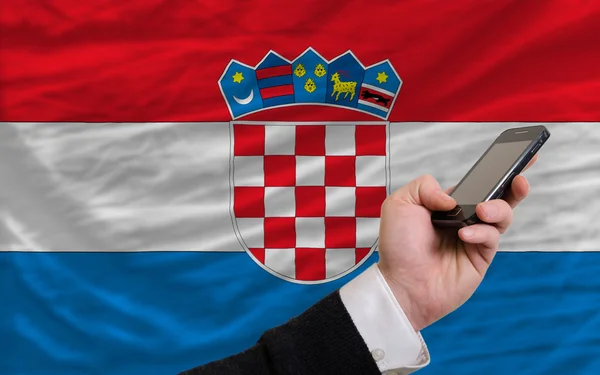 Teléfono celular frente a bandera nacional de croacia — Foto de Stock