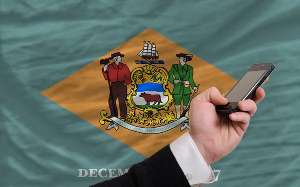 Mobilen framför flagga av amerikanska delstaten delaware — Stockfoto