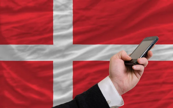 Téléphone portable devant le drapeau national du Danemark — Photo