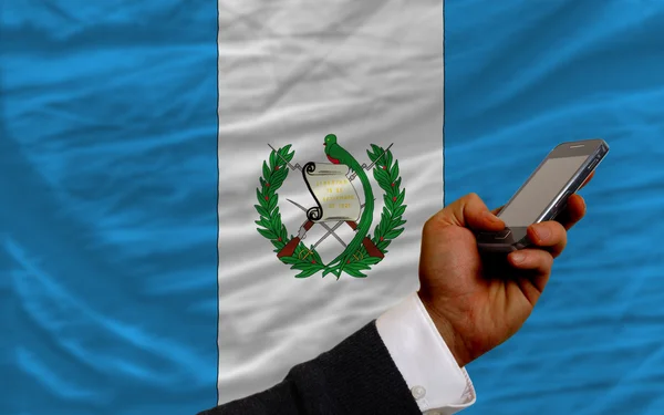 Telefone celular na frente bandeira nacional de guatemala — Fotografia de Stock
