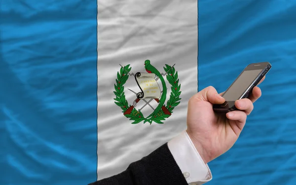 Mobiltelefon i främre nationella flagga i guatemala — Stockfoto