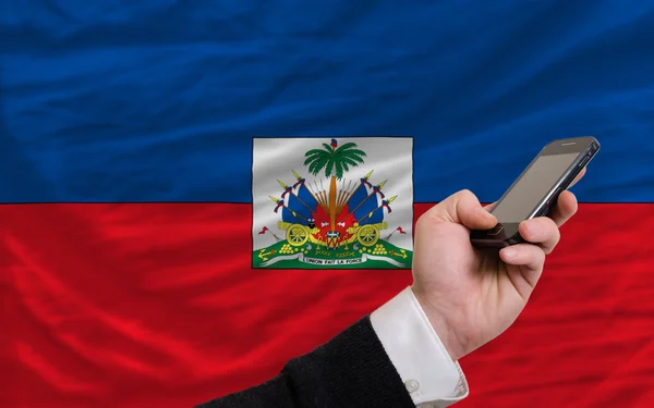 Mobiltelefon i främre nationella flagga i haiti — Stockfoto