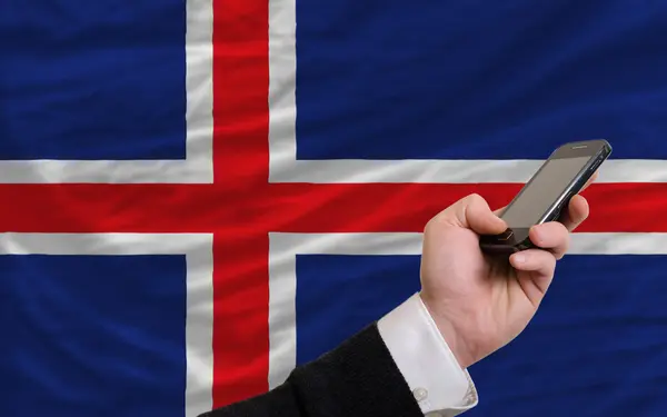 Mobiltelefon i främre nationella flagga Island — Stockfoto