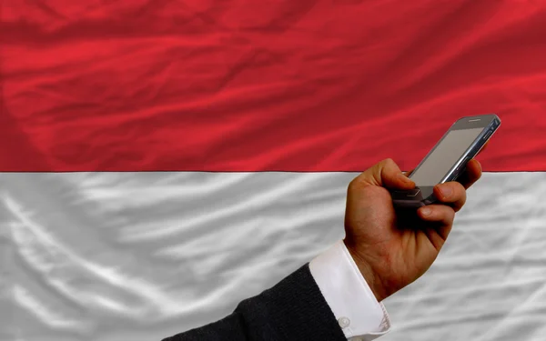 Handy vor Nationalflagge Indonesiens — Stockfoto