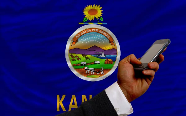 Teléfono celular frente a la bandera del estado americano de Kansas —  Fotos de Stock