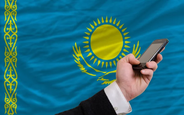 Mobilní telefon v přední národní vlajka kazašské — Stock fotografie