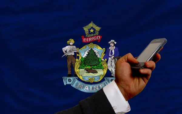 Κινητό τηλέφωνο μπροστά σημαία της Αμερικανικής πολιτείας του maine — Φωτογραφία Αρχείου