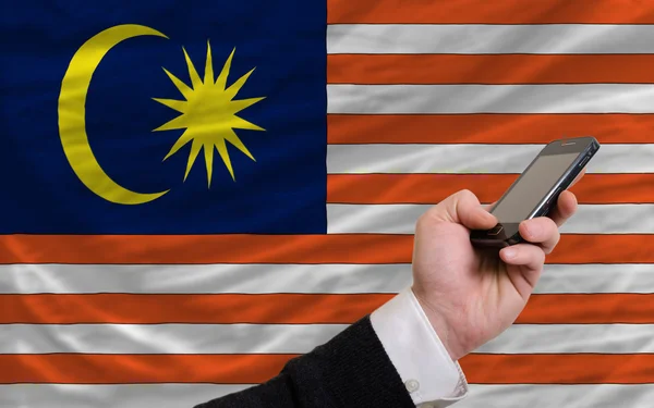 Mobiltelefon i främre nationella flagga malaysia — Stockfoto