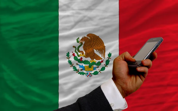 Mobiele telefoon in front nationale vlag van mexico — Stockfoto