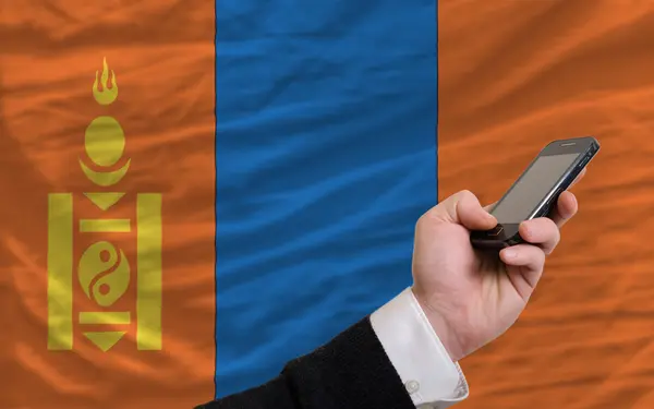 Mobiele telefoon in front nationale vlag van Mongolië — Stockfoto